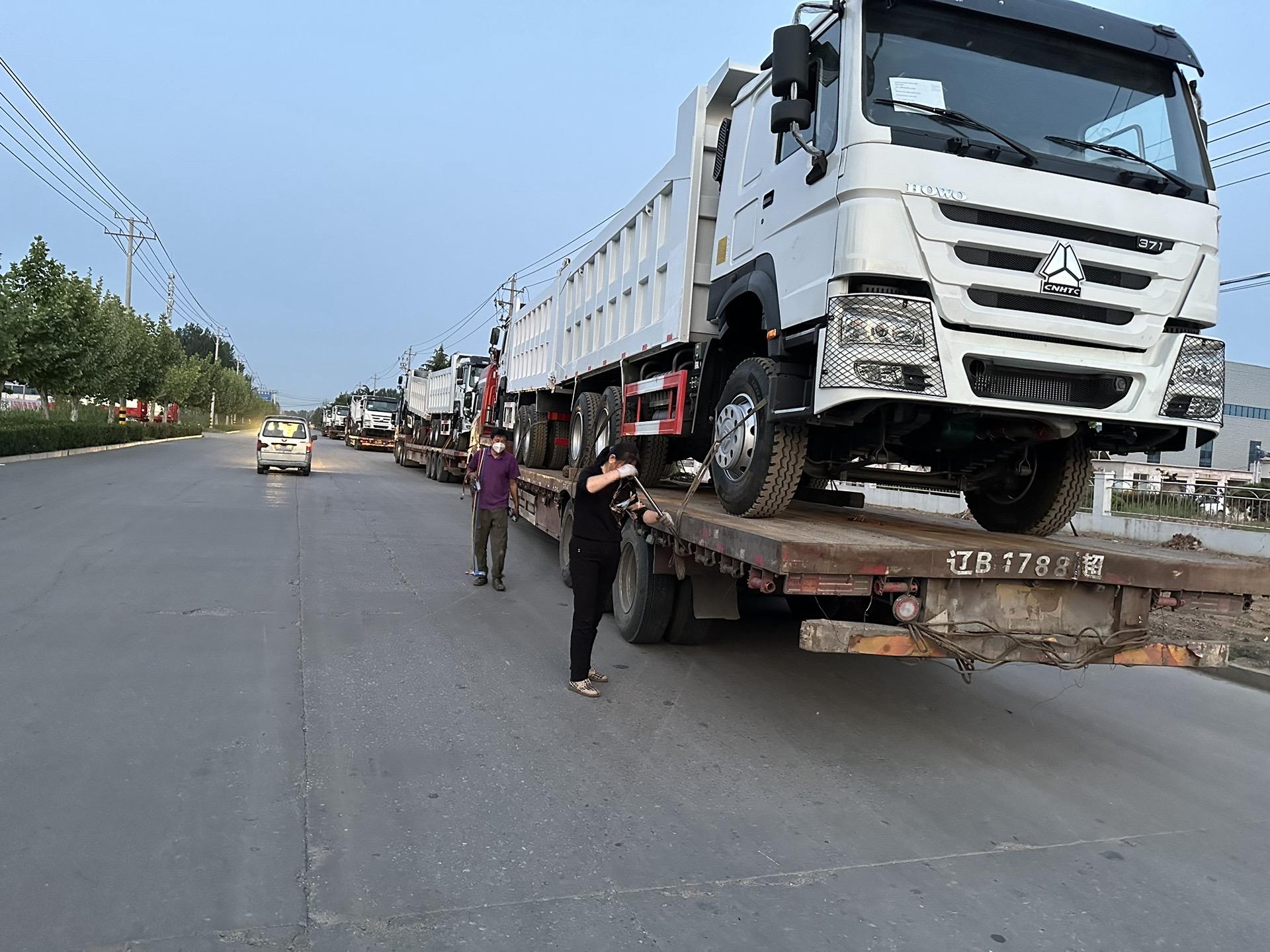 Camions bennes HOWO chargés sur un plateau pour livraison export