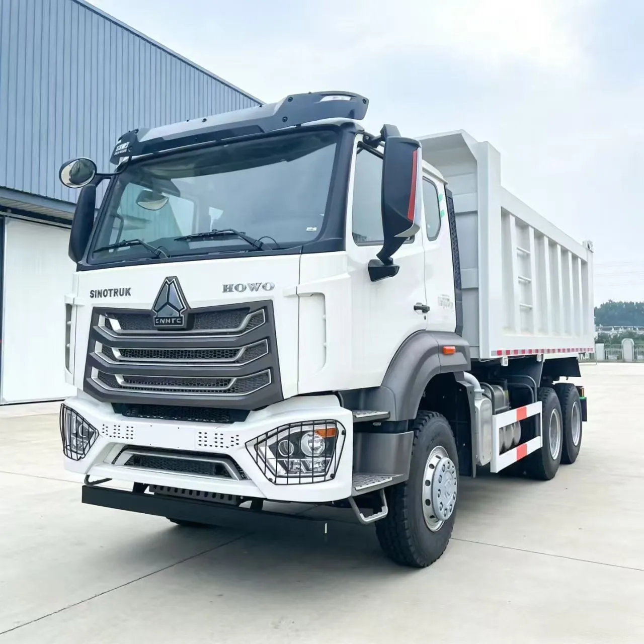 Camion benne HOHAN 6x4 occasion prêt à l'export, montrant la caisse et les essieux moteurs