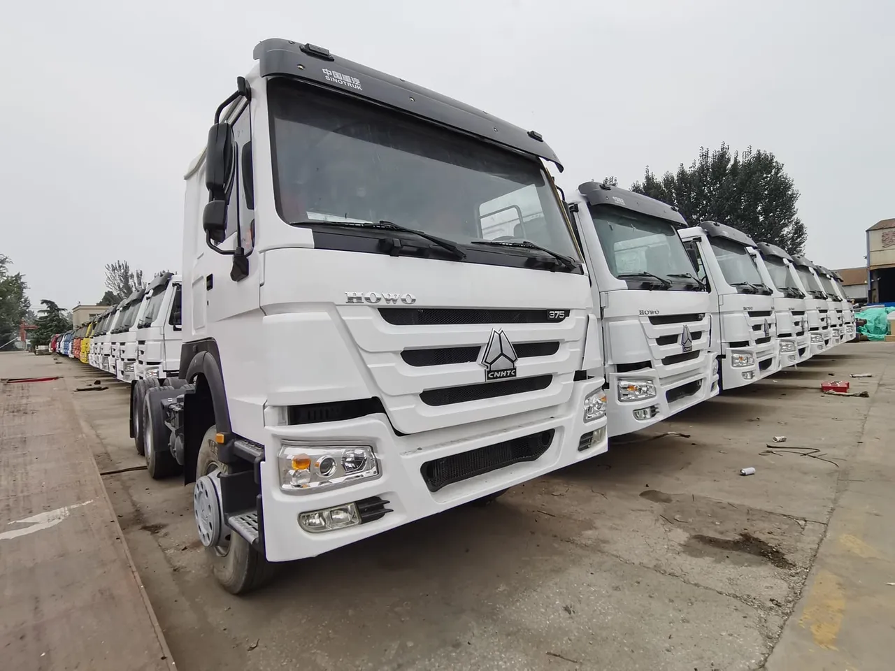 Kepala trailer HOWO bekas 6x4 berjajar di yard ekspor Sigma Truck siap kirim CIF ke Afrika